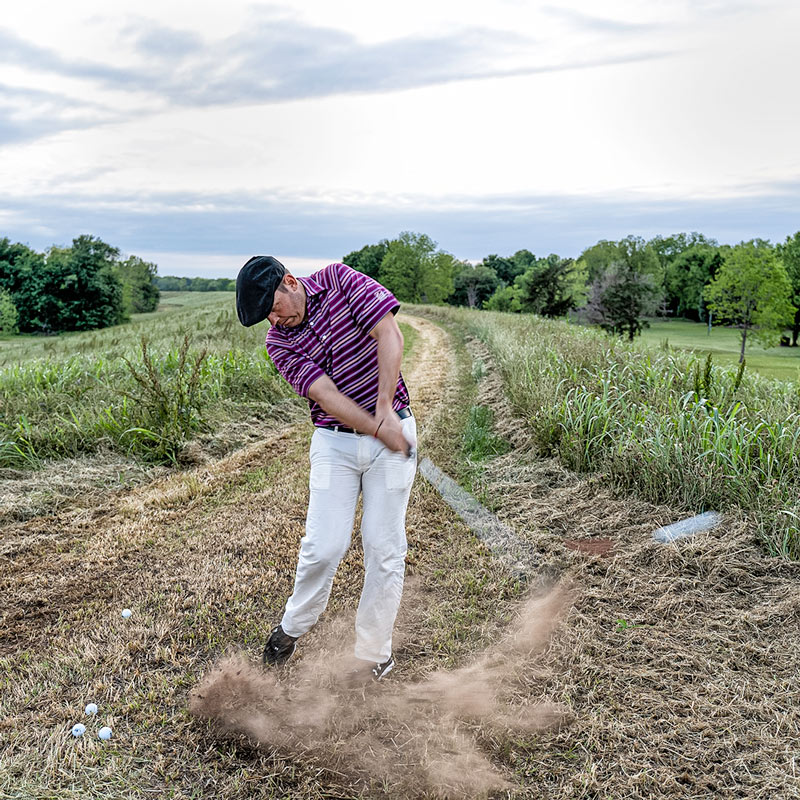 guy hitting a golf ball